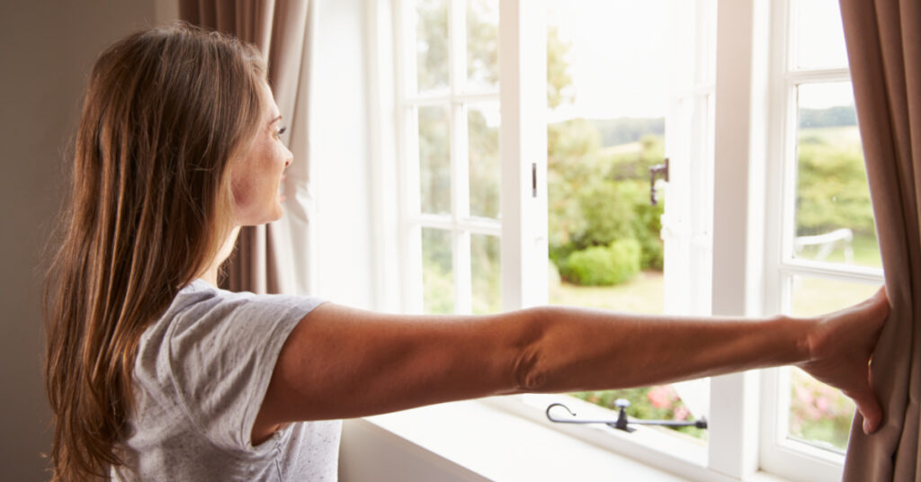 woman opening window
